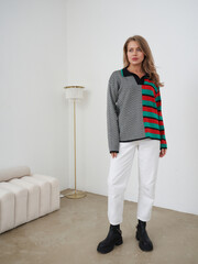 Blonde woman poses in stylish clothing in a modern studio setting