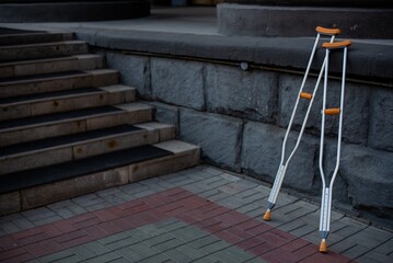 Pair of crutches for a man with an injury on the stairs.