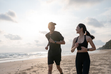 Young men and women run along the sea or beach to promote health, strength and quality of life,...