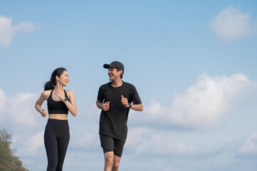 Young men and women run along the sea or beach to promote health, strength and quality of life,...