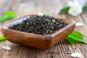 Fresh Green Tea Leaves in Wooden Bowl.