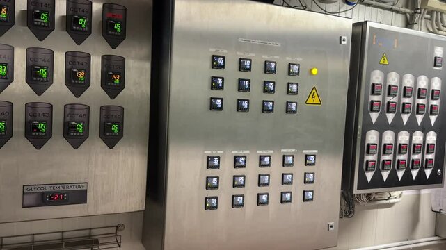 Stainless steel industrial control panels with digital displays showing temperature readings and labeled CCT units for brewery fermentation monitoring.
