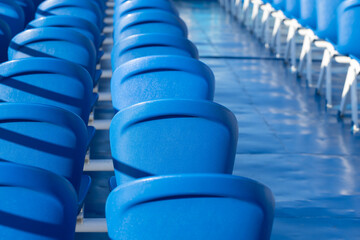 Fototapeta na wymiar An arrangement of bright blue stadium seats, closeup abstract photo