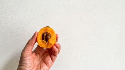 A hand cradles a ripe loquat, evoking golden summer harvest, Solstice fruit rituals, and unexpected...