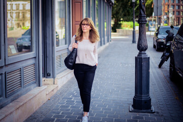 Blond haired woman walking down the city street