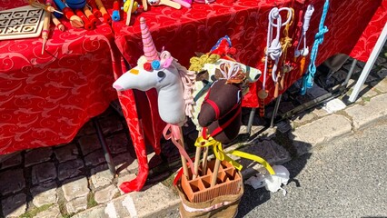 Whimsical unicorn and horse stick toys amidst vibrant Nordic midsummer fair, evoking childhood...