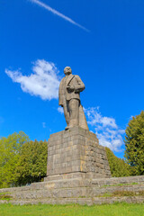 Obraz premium A monument to the Soviet leader against the backdrop of a blue sky with clouds.