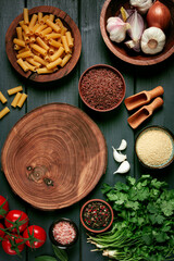 food concept, wooden chopping board, on a wooden table, with ingredients, spices and herbs, top view, vertical, no people,