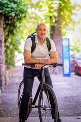 Obraz premium Mid aged man using a bicycle on sthe street downtown