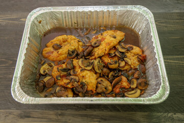 A baking dish with Chicken in a rich Marsala wine sauce and mushrooms.