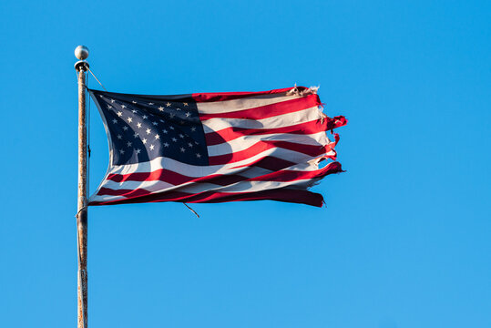 Tattered American Flag Blowing in Wind