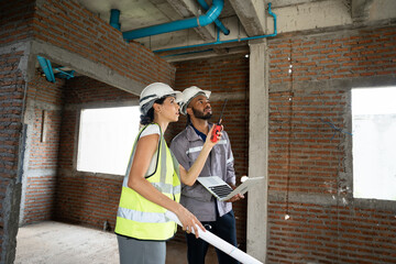 Two Engineer builder. Foreman use notebook computer working in construction site.	