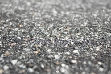 Asphalt Texture close up: The gritty and granular texture of asphalt is showcased up close, the image offering a detailed and textured view of the road surface.