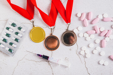Concept of doping in sports, close up of medals, pills and syringe on the table top view