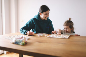 Mother teaches her little girl letters through play
