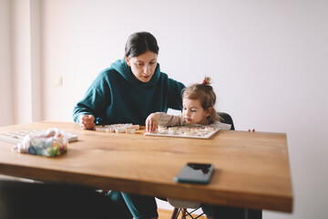 Mother teaching her daughter letters