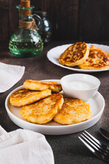 Crispy mashed potato pancakes and gravy on a plate on the table vertical view