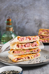 Grilled sandwiches in pita bread with sausage and cheese on a plate vertical view