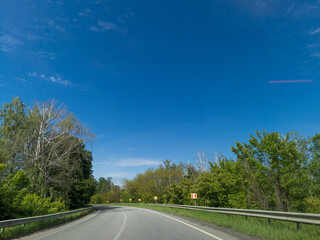 A long empty road in the middle of a forested area