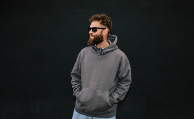 Bearded hipster in dark grey hoodie and sunglasses &ndash; urban apparel mockup
