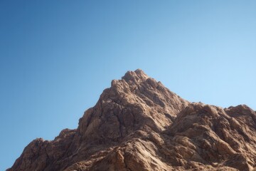 close-up of rugged mountain peak under clear blue sky with ample copy space