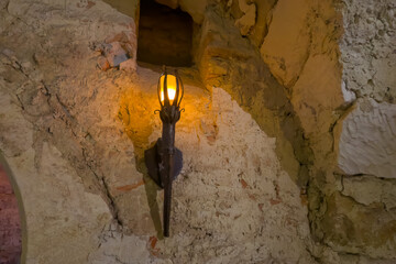 Electric lamp simulating a flaming torch in dungeon of castle