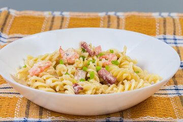 Spiral pasta with boiled seafood in white souse, front view