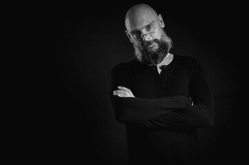 Black and white portrait, emotional bearded man in glasses, grimacing and grimacing at the camera. Dramatic portrait in dim lighting, expressive face, emotional tension, dark background.