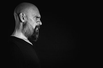 Black and white portrait, emotional bearded man in glasses, grimacing and grimacing at the camera....