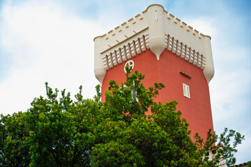 Chateau de Cremat red tower building near a green tree over blue sky