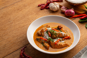 Canned Mackerel fish with red curry sauce topped with shredded kaffir lime leaves and chilli,Thai Chu Chee Fish Curry with coconut milk in white plate.