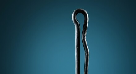 Close-up of a simple cotter pin against a textured blue background