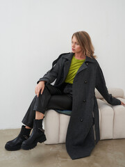 Stylish young woman posing in a fashionable outfit in a modern studio setting