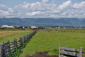 Russia. The Republic of Buryatia. View of fields in the valley of the Irkut river enclosed by...
