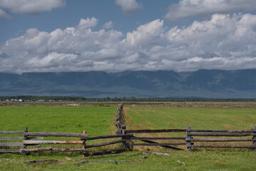 Russia. The Republic of Buryatia. View of fields in the valley of the Irkut river enclosed by wooden fences of a special zigzag structure made of logs.