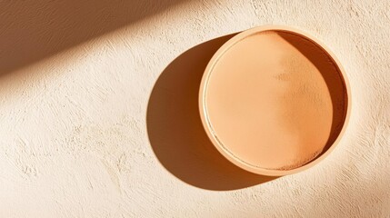 Close-up of a round, orange-colored object on a beige-colored wall. the object appears to be made of ceramic or porcelain and has a smooth, oval shape.