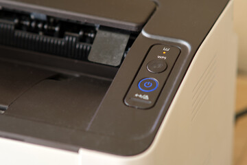 Close-up of laser printer control panel with orange toner alert indicator, power button and WPS...
