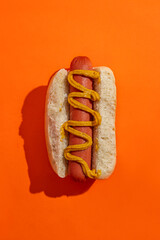 Classic Hot Dog with Mustard on a orange background