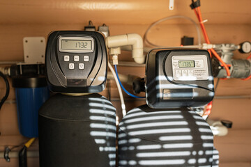 Modern water filtration and heating system installed in a utility room, featuring digital control...