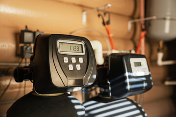 Modern water filtration and heating system installed in a utility room, featuring digital control...