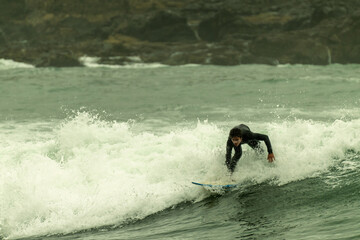 Surfer riding wave on cloudy morning in wetsuit