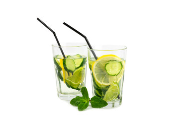 Cucumber water with lemon, lime and mint isolated on white background. Water infused with sliced ​​cucumber in a drinking glass. Tonic refreshing drink. Cucumber lemonade.Summer natural cooling drink