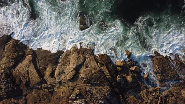 Olas del mar batiendo contra la costa rocosa, vista desde arriba