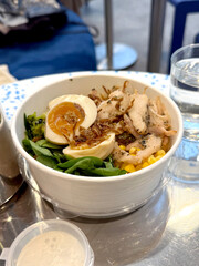 Bowl with Corn, Spinach, Egg, Chicken, and Crispy Bacon on Table. Modern Kitchen Concept. Handmade Mobile Photo, Selective Focus, Not AI