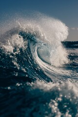 A majestic wave curls and crashes, spraying water into the clear sky.