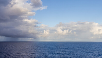 Fototapeta premium Serene Ocean View Underneath Dramatic Cloudscape with Hints of Blue Sky