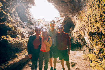 Family exploring a lava cave wearing headlamps during an underground excursion