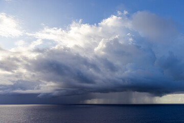 Obraz premium Dramatic Oceanic Cloudscape with Sunlight Piercing Through Over the Tranquil Waters