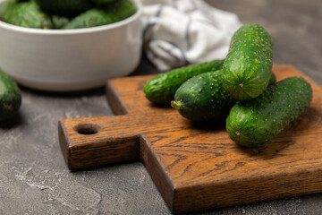 Cucumber on wooden background. Slice of cucumber on background. Fresh organic green cucumbers gherkin. Vegan. Salad ingredient. Farm vegetables. Cut vegetables with knife. Space for text. Copy space