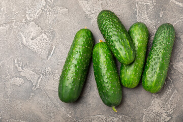 Cucumber on wooden background. Slice of cucumber on background. Fresh organic green cucumbers gherkin. Vegan. Salad ingredient. Farm vegetables. Cut vegetables with knife. Space for text. Copy space